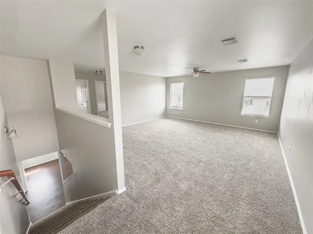an empty room with a empty space and a ceiling fan