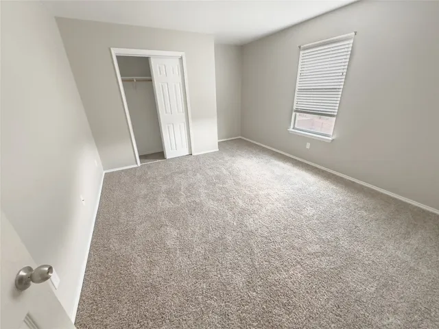 an empty room with windows and chandelier fan