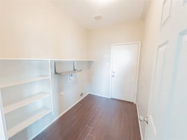 a view of a hallway with wooden floor and entryway