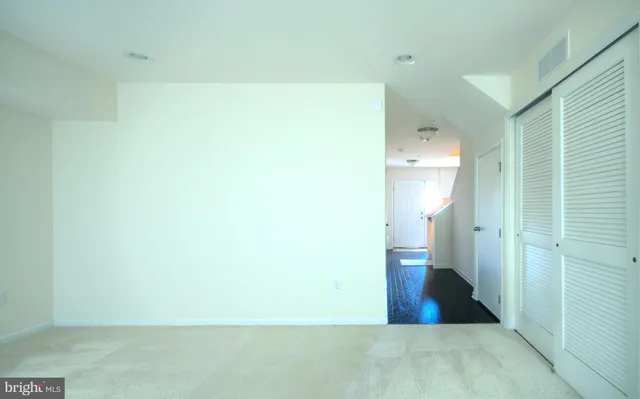 an empty room with closet and windows