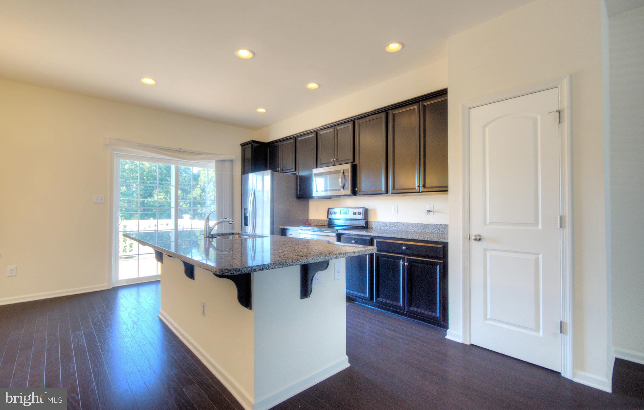 58 Iron Gate Road Marlton, NJ 08053 - Photo 26 of 47 a kitchen with kitchen island granite countertop wooden floors and stainless steel appliances