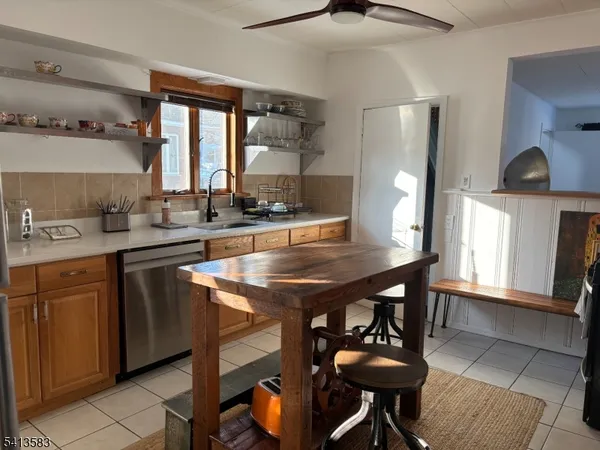 a kitchen with stainless steel appliances granite countertop a sink a stove and chairs