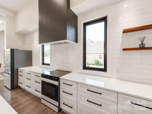a kitchen with granite countertop white cabinets and black stainless steel appliances