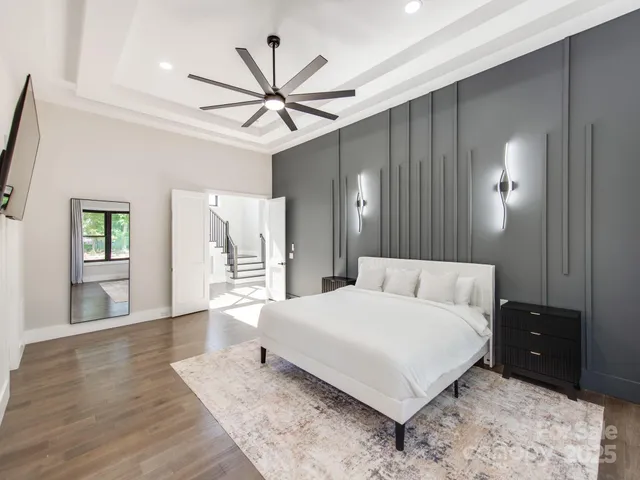 a bedroom with a large bed and a chandelier