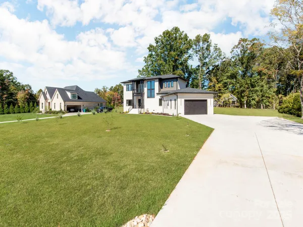 a view of house with yard and trees in the background