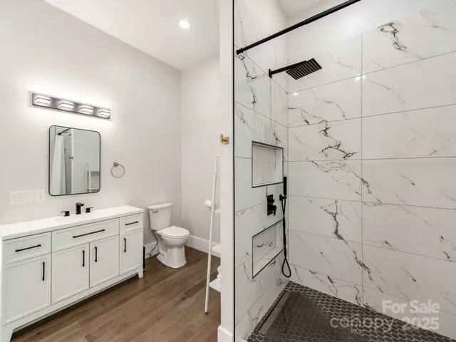 a en suite bathroom with a double vanity sink a toilet and a mirror
