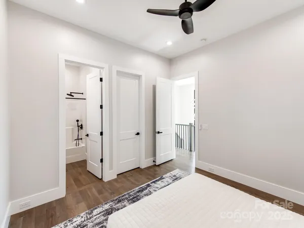 a view of a hallway with bathroom and wooden floor