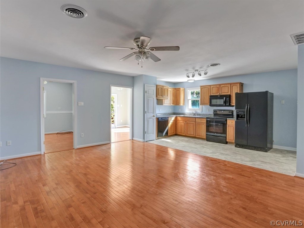 9201 Cattail Road Chesterfield, VA 23838 - Photo 6 of 35 a view of a kitchen with a sink refrigerator a ceiling fan and wooden floor
