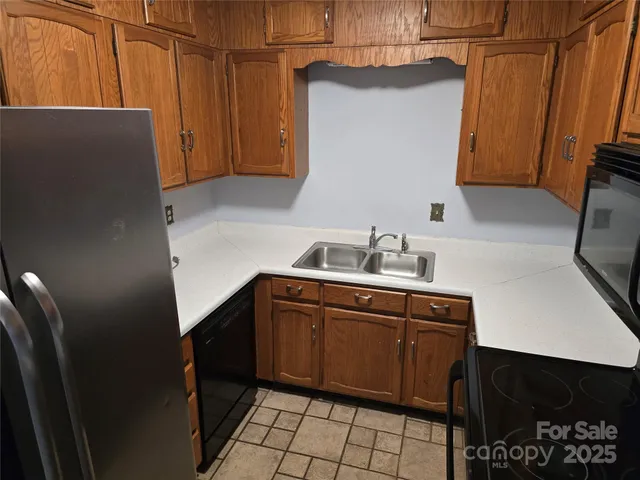a kitchen with a sink a refrigerator and cabinets