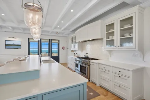 a living room with stainless steel appliances kitchen island granite countertop a sink cabinets and wooden floor