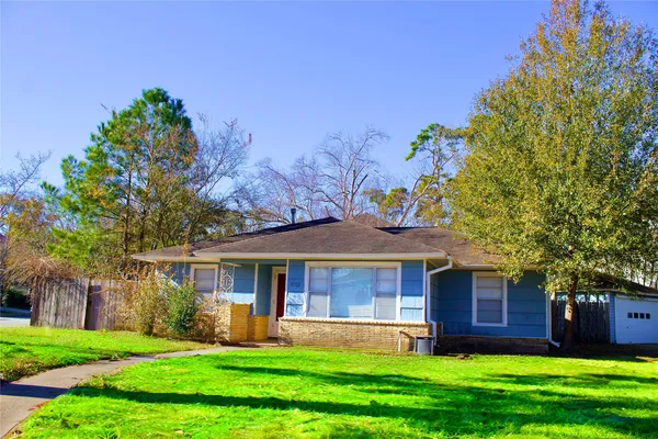 a front view of a house with a garden and trees