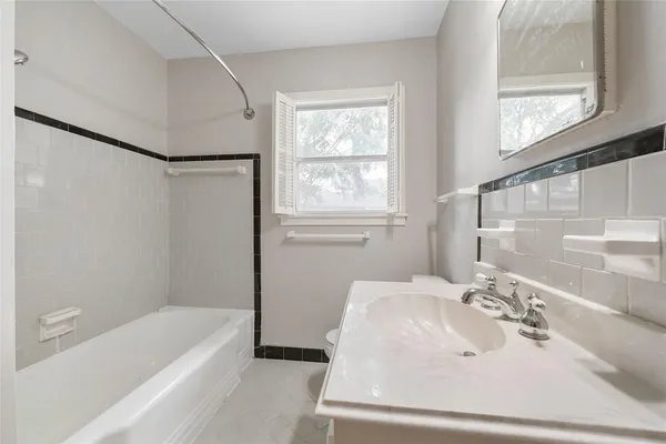 a bathroom with a sink a mirror and a bathtub