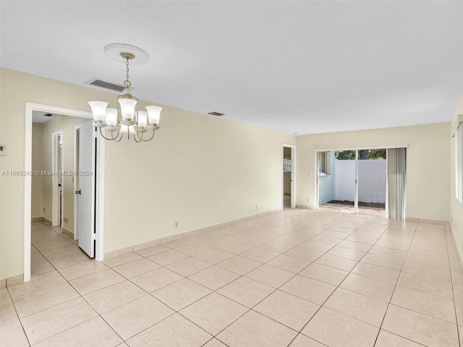 9185 Southwest 5th Street, Unit B Boca Raton, FL 33428 - Photo 14 of 38 a view of an empty room with a chandelier