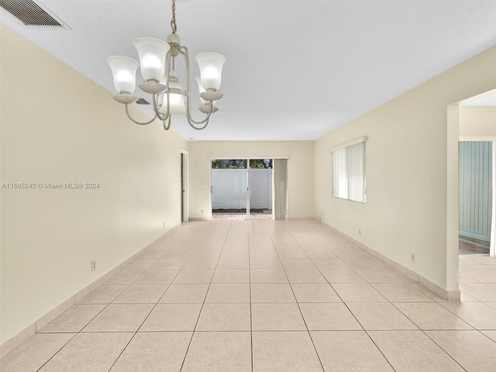 9185 Southwest 5th Street, Unit B Boca Raton, FL 33428 - Photo 16 of 38 a view of an empty room with glass door and windows