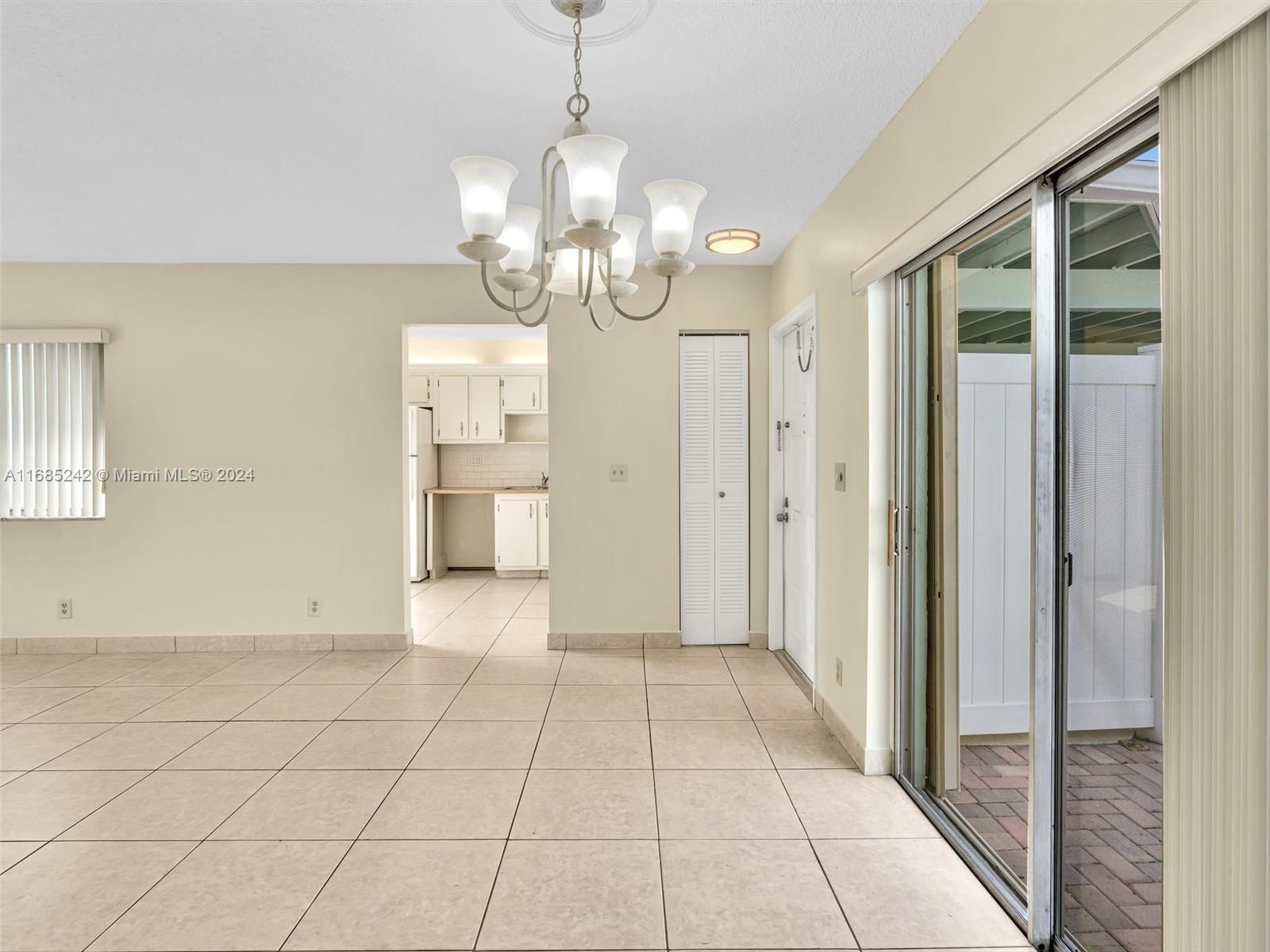 9185 Southwest 5th Street, Unit B Boca Raton, FL 33428 - Photo 17 of 38 a view of a hallway with wooden floor and chandelier