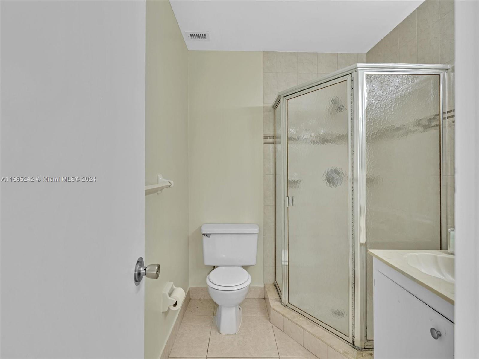 9185 Southwest 5th Street, Unit B Boca Raton, FL 33428 - Photo 37 of 38 a bathroom with a toilet shower vanity and a sink