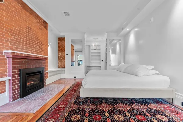 a spacious bedroom with a bed and a fireplace
