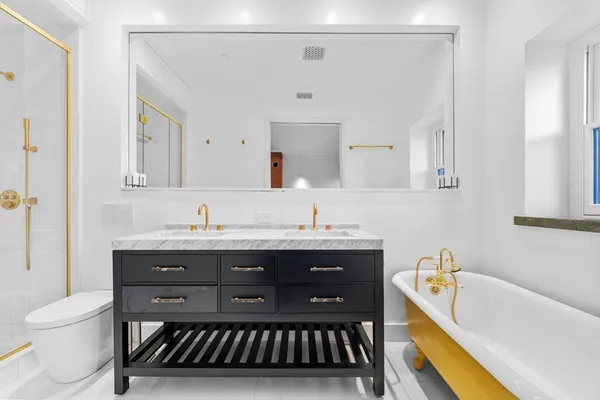 a bathroom with a granite countertop sink a toilet and bathtub