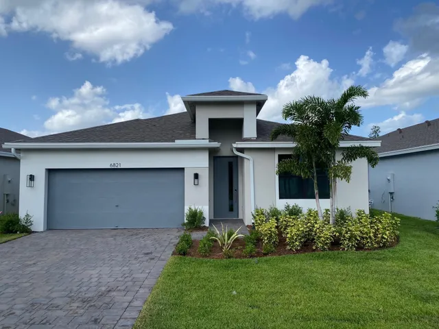 a front view of a house with a garden and garage