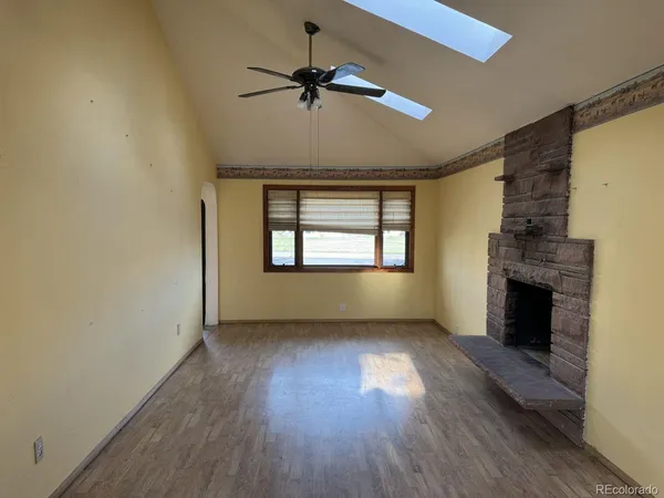 a view of an empty room with a fireplace and a window