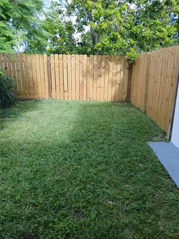 a view of a yard with a wooden fence