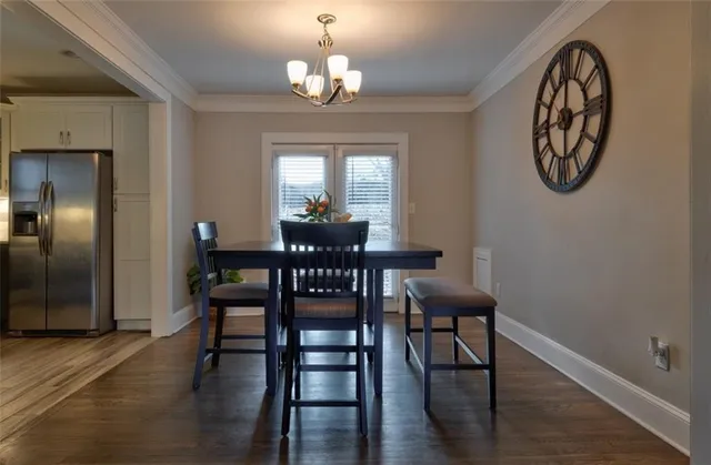 a view of a dining room with furniture a chandelier and wooden floor