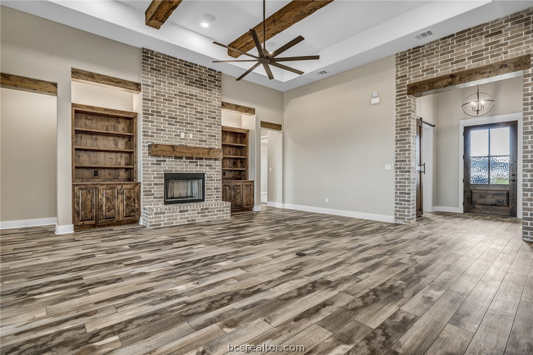 a view of an empty room with a fireplace and a window