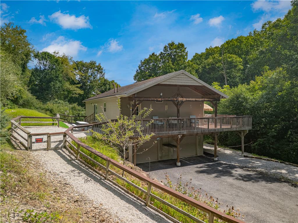 7353 Farrier Road Orefield, PA 18069 - Photo 62 of 74 Wood posts support an expansive elevated deck overlooking the gravel driveway and surrounding forest.