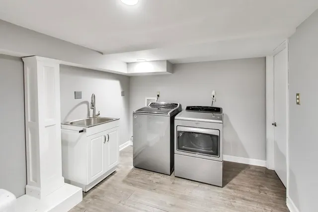 a kitchen with stainless steel appliances white cabinets and wooden floor