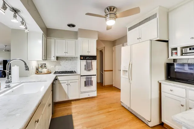 a kitchen with stainless steel appliances a refrigerator sink and white cabinets