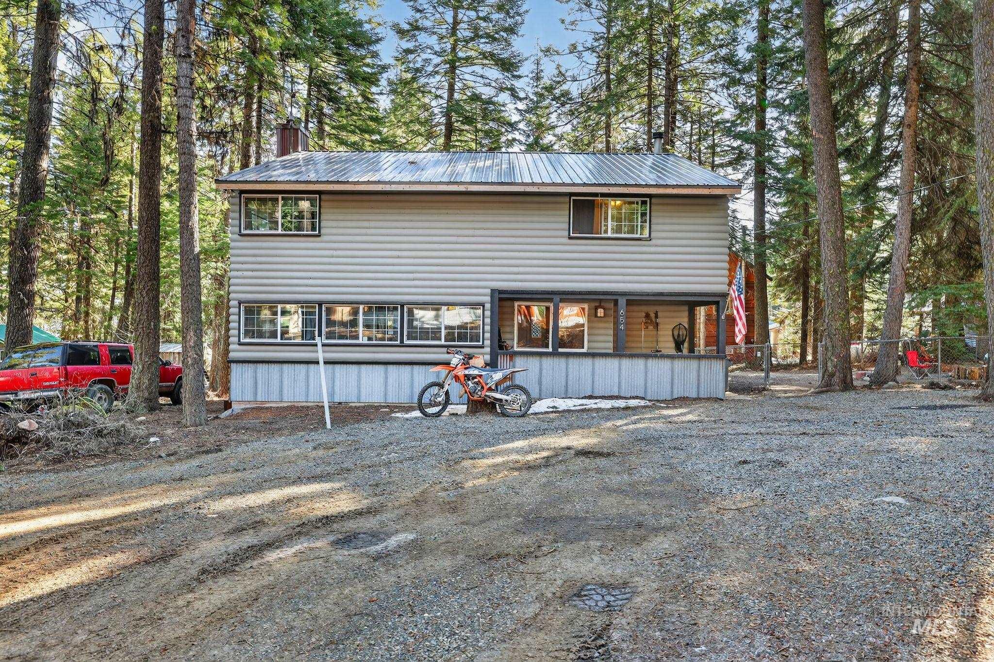 View of front of house featuring a metal roof and a chimney