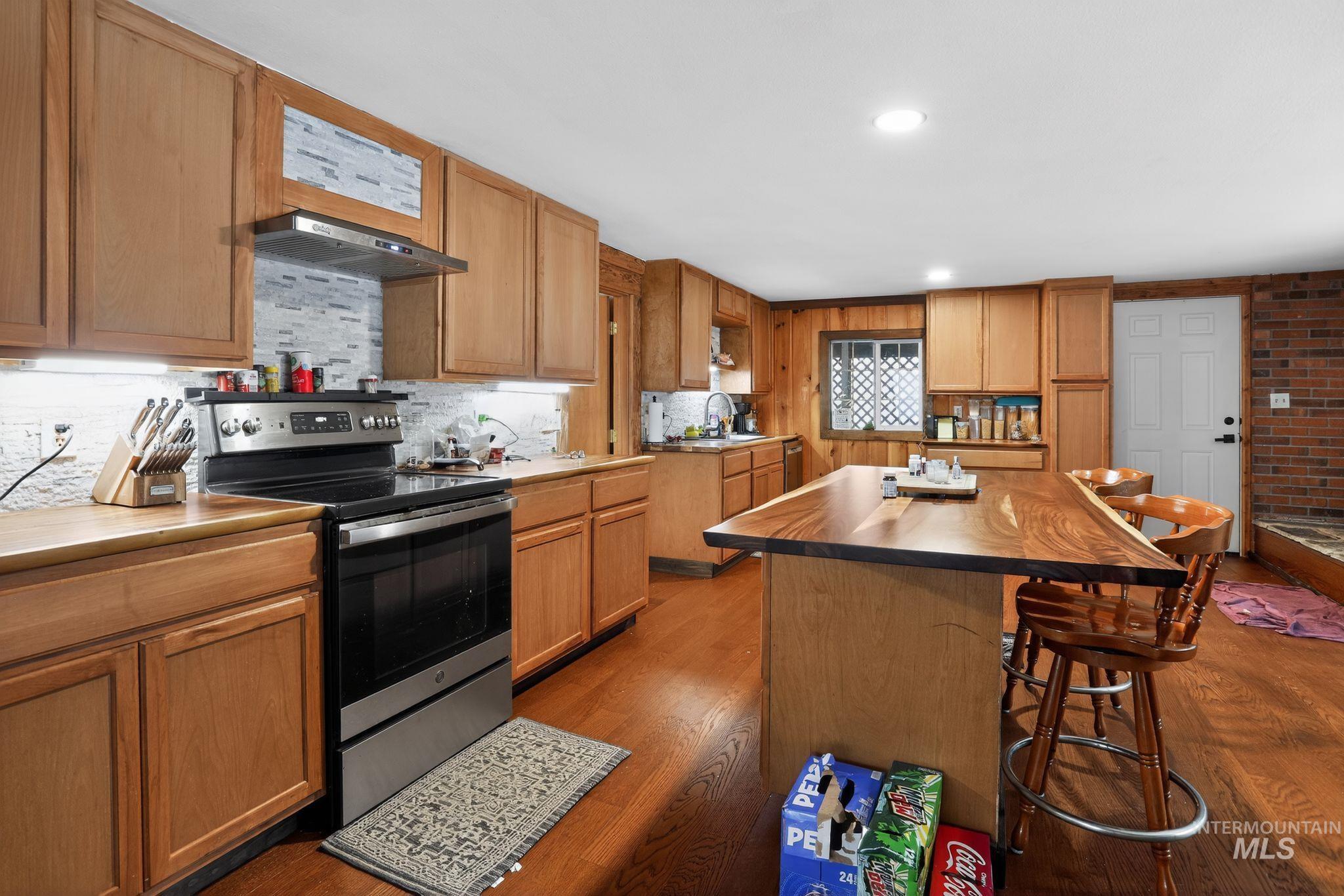 654 Bings Road Cascade, ID 83611 - Photo 12 of 40 Kitchen featuring electric stove, a kitchen breakfast bar, dark wood-style floors, a kitchen island, and recessed lighting