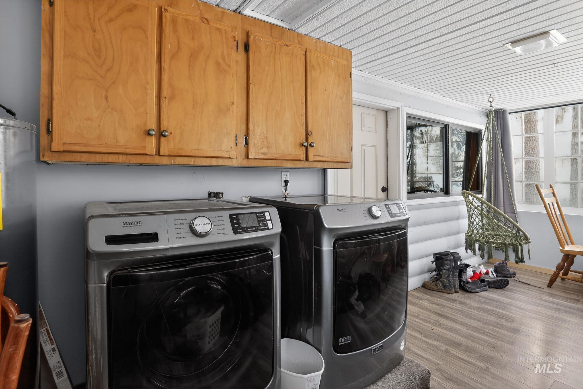 654 Bings Road Cascade, ID 83611 - Photo 16 of 40 Laundry area with wood finished floors, washer and dryer, water heater, and cabinet space