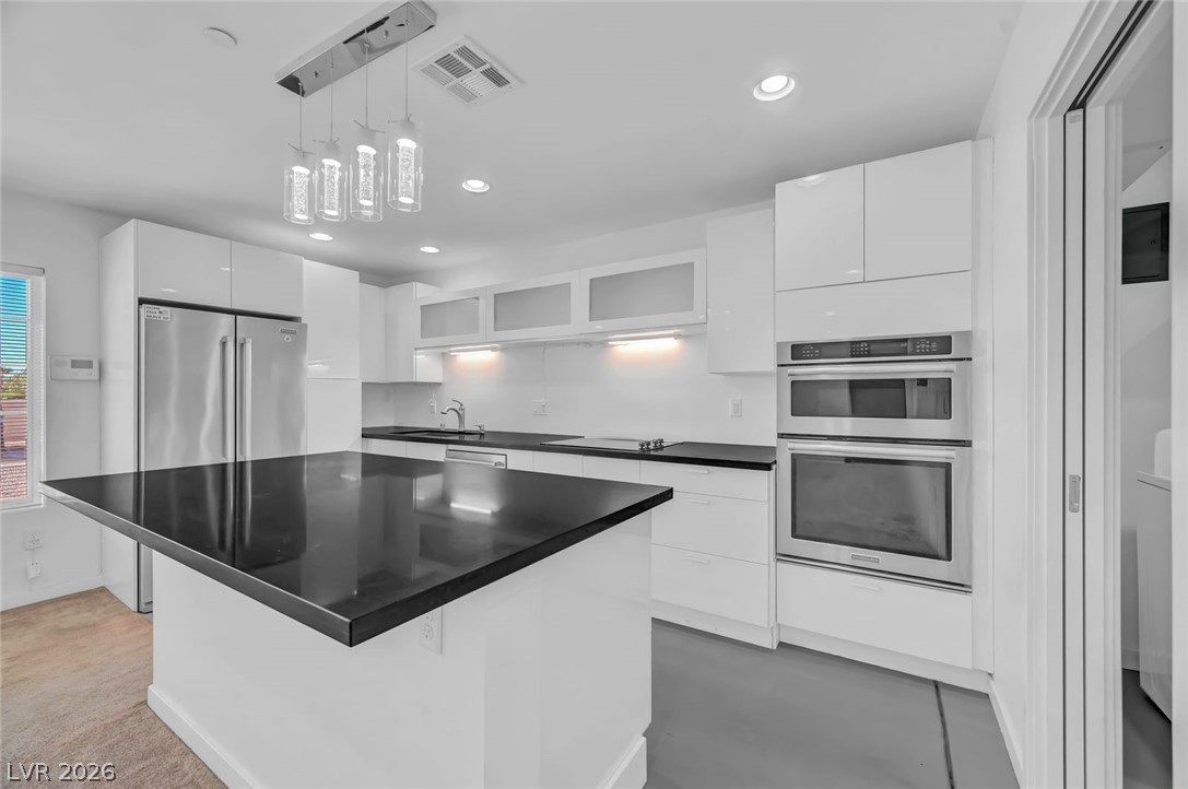 640 North Racetrack Road Henderson, NV 89015 - Photo 49 of 65 A sleek island kitchen featuring modern design and high-end stainless steel appliances.