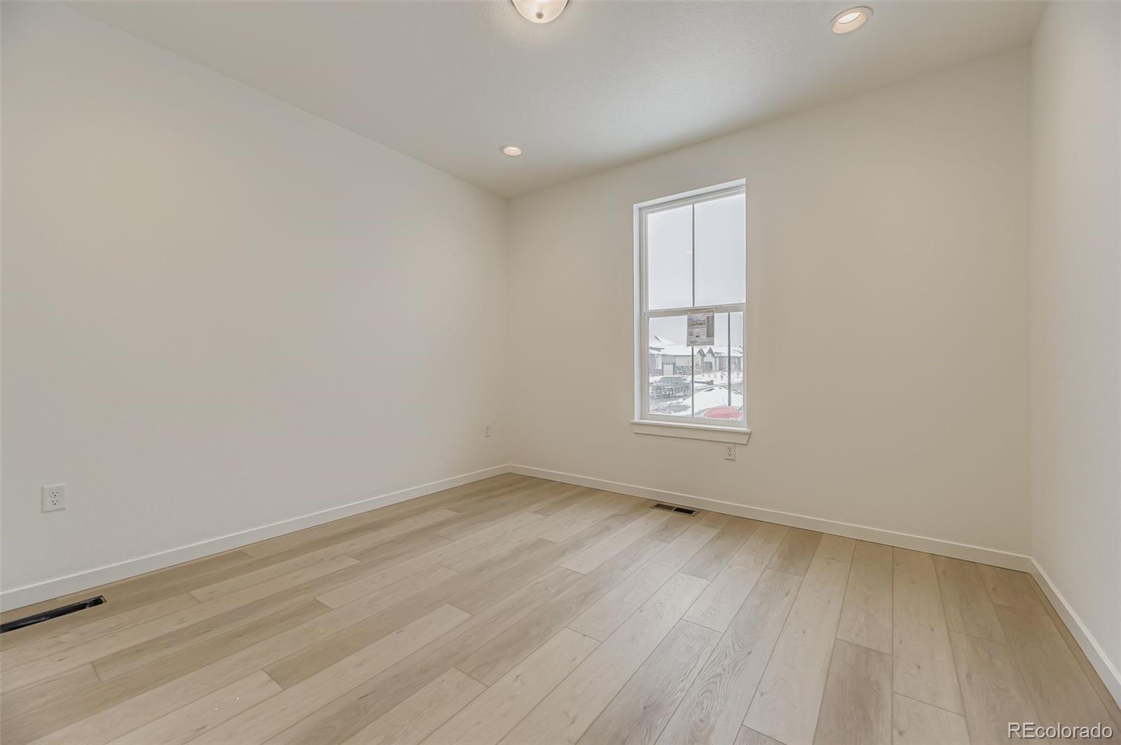 8895 South Riviera Way Aurora, CO 80016 - Photo 17 of 26 an empty room with wooden floor and windows