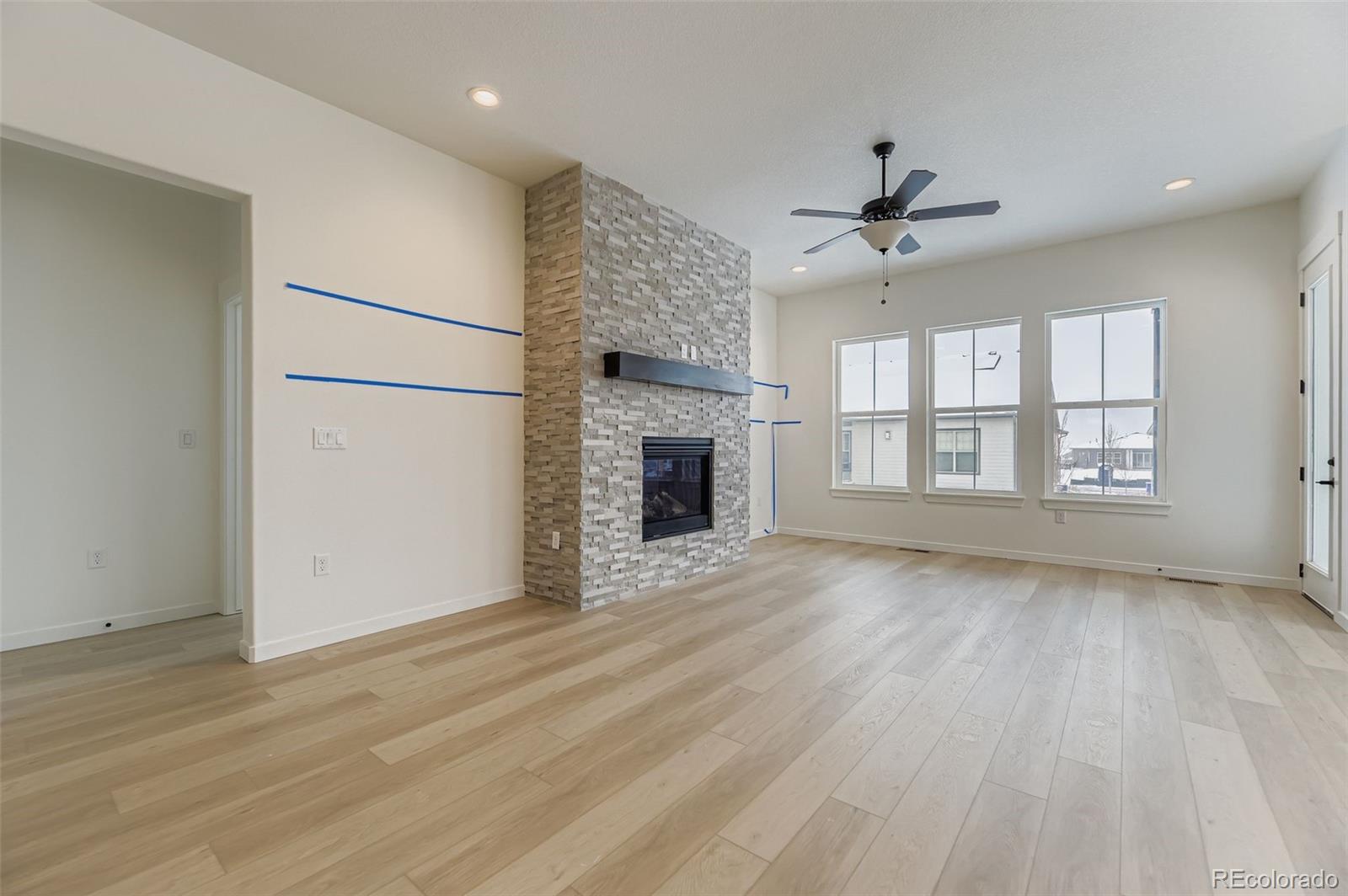 8895 South Riviera Way Aurora, CO 80016 - Photo 5 of 26 an empty room with wooden floor fireplace and windows
