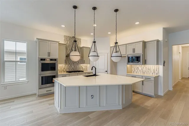 a kitchen that has a lot of cabinets in it and wooden floors