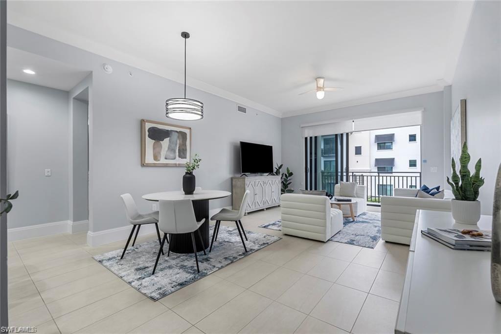 1030 3rd Avenue South, Unit 315 Naples, FL 34102 - Photo 11 of 29 a living room with furniture a flat screen tv and a window