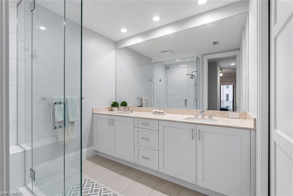 1030 3rd Avenue South, Unit 315 Naples, FL 34102 - Photo 20 of 29 a bathroom with a double vanity sink and mirror