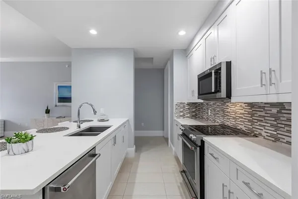 a kitchen with a sink appliances and cabinets
