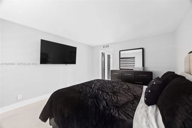 a bedroom with a bed tv and window