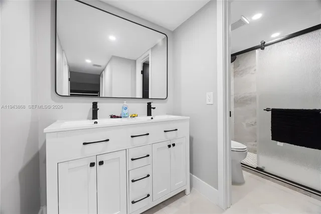 a bathroom with a double vanity sink toilet and mirror
