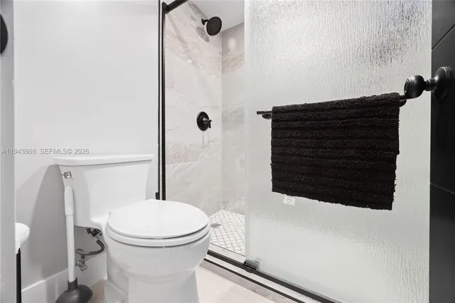 a bathroom with a toilet and a shower