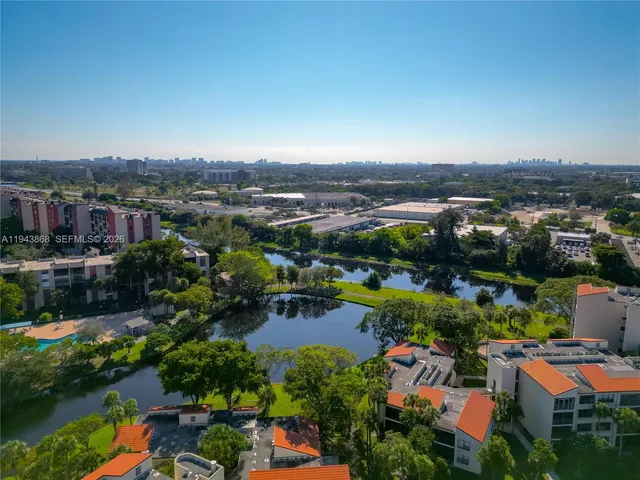 an aerial view of a houses with a lake view and large trees