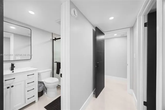 a bathroom with a bathtub sink mirror vanity and toilet