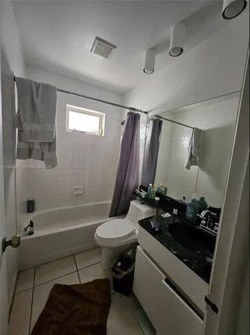 a bathroom with a sink a toilet a mirror and bathtub