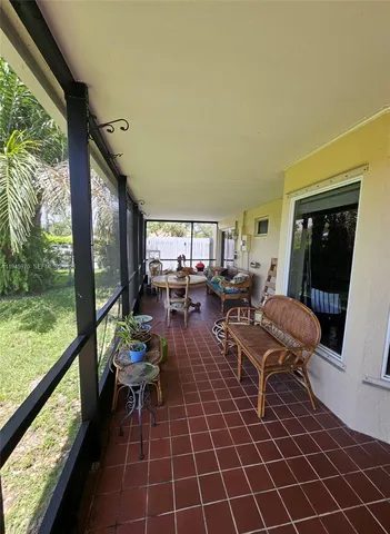 a living room with patio furniture and a floor to ceiling window