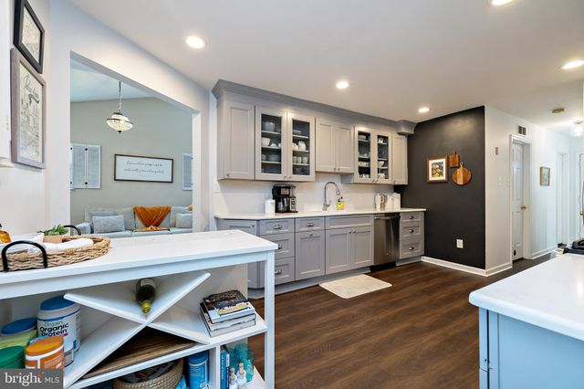 a kitchen with a sink cabinets and wooden floor