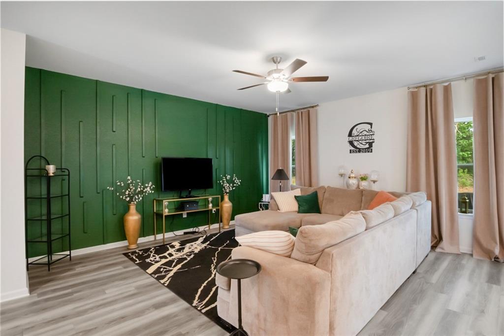 217 Limestone Circle Conyers, GA 30013 - Photo 8 of 21 a living room with furniture a flat screen tv and a large window