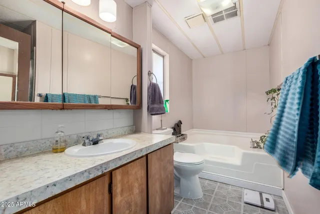 a bathroom with a granite countertop sink mirror vanity and toilet